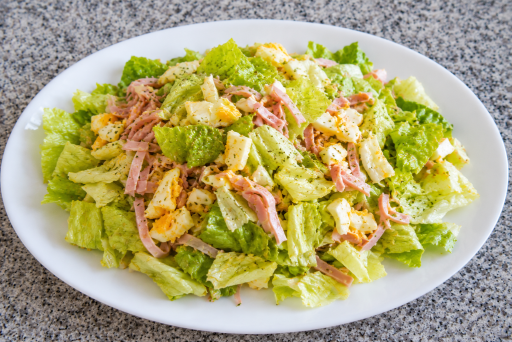 Imagen actual: Ensalada saludable de lechuga, huevo duro y jamón de pavo aliñada con aceite de oliva virgen.